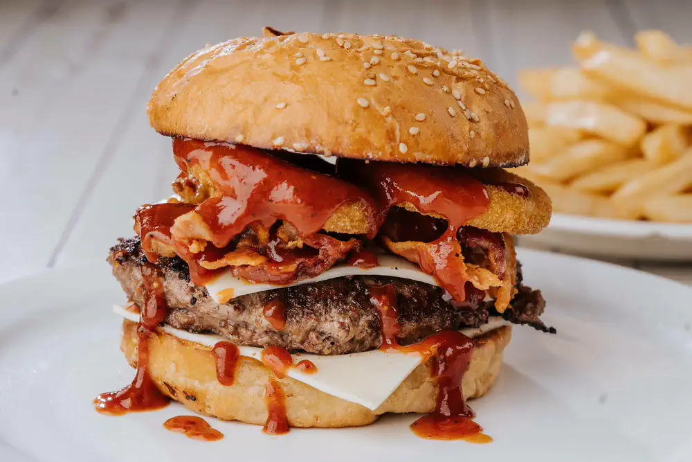 Hamburguesa con tocino, queso y salsa BBQ, con papas a la francesa