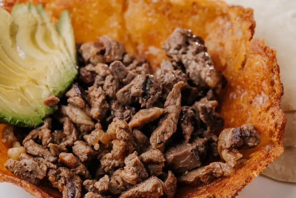 Quesadilla dorada rellena de carne asada con aguacate